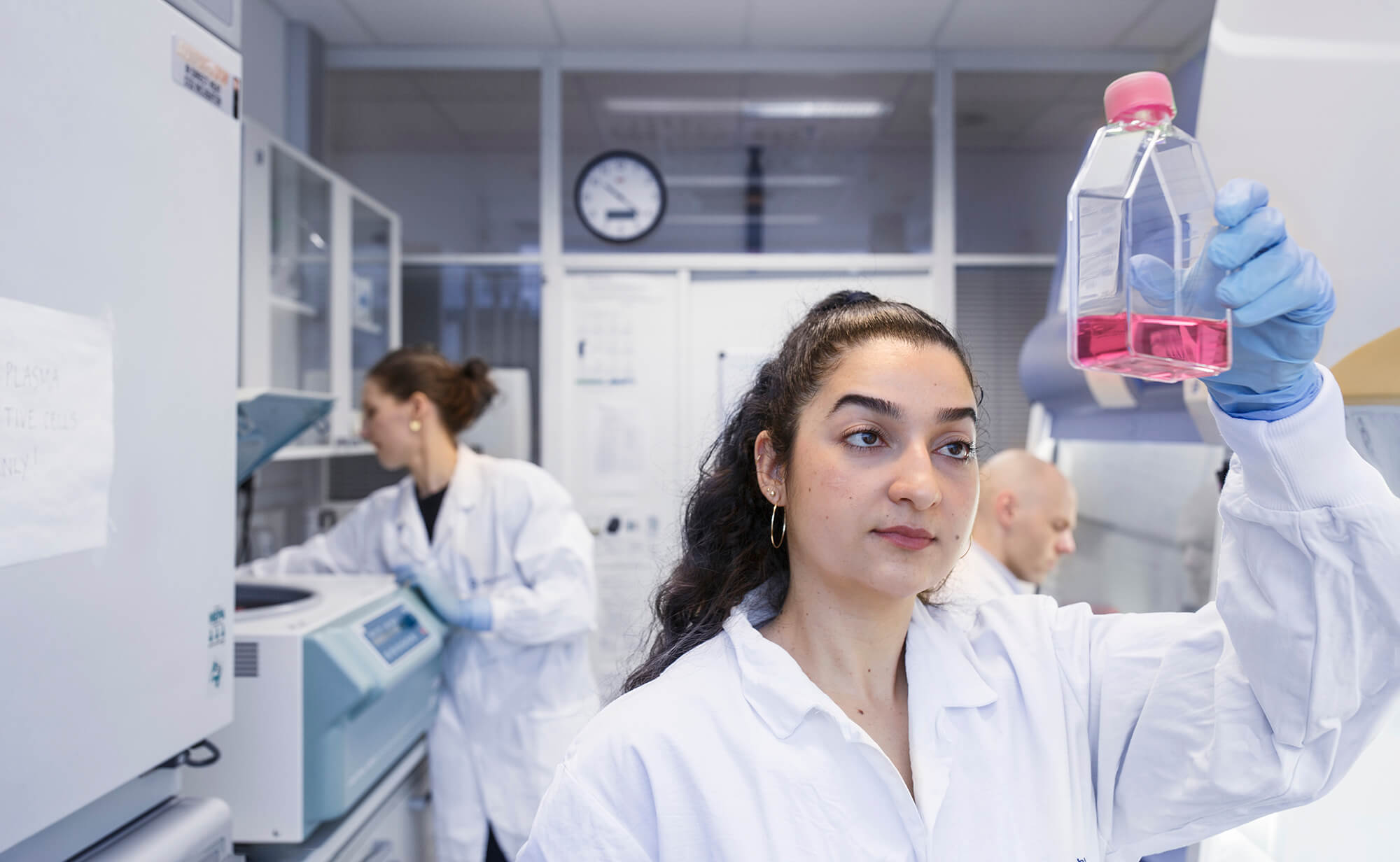Forskere med flaske laboratorium kvinnehelse Radiumhospitalet (Tomas Gunnarson)