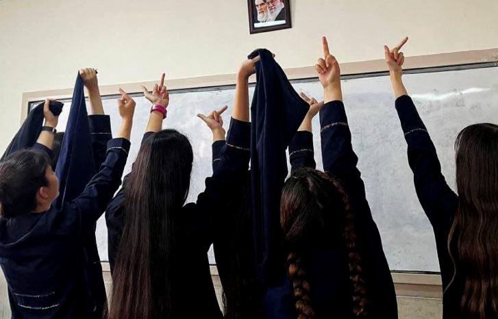 Iranske kvinner viser fingeren til et bilde av Khomeini