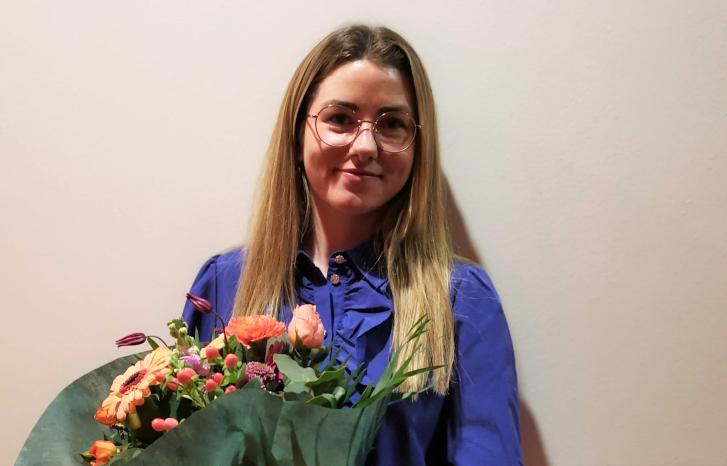 Ung kvinne med blomster i armene