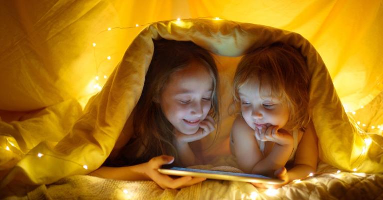 Two girls reading in a tent