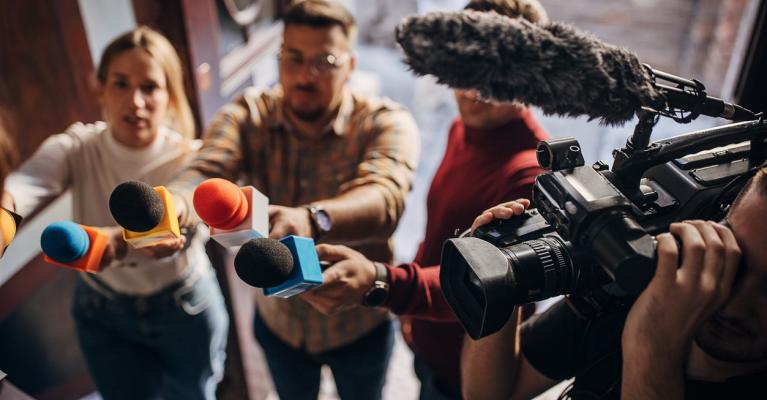 Journalister retter mikrofoner og kamera mot intervjuobjekt