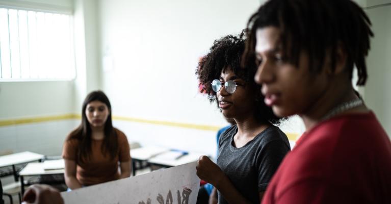 Tre brune ungdommer forbereder en antirasist-demonstrasjon