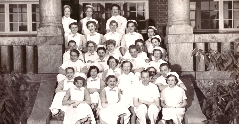 Bildet fra 1954 viser ferdige sykepleiere ved Rigshospitalet – med de første sju mannlige sykepleierne i Danmark. 