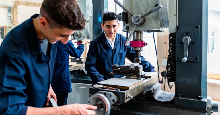 To lærlinger-gutter får undervisning på verksted