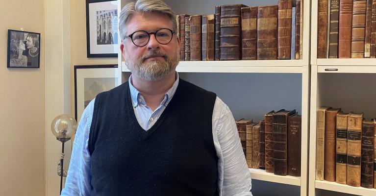 Jussprofessor Jørn Øyrehagen Sunde står foran bokhylla på kontoret sitt