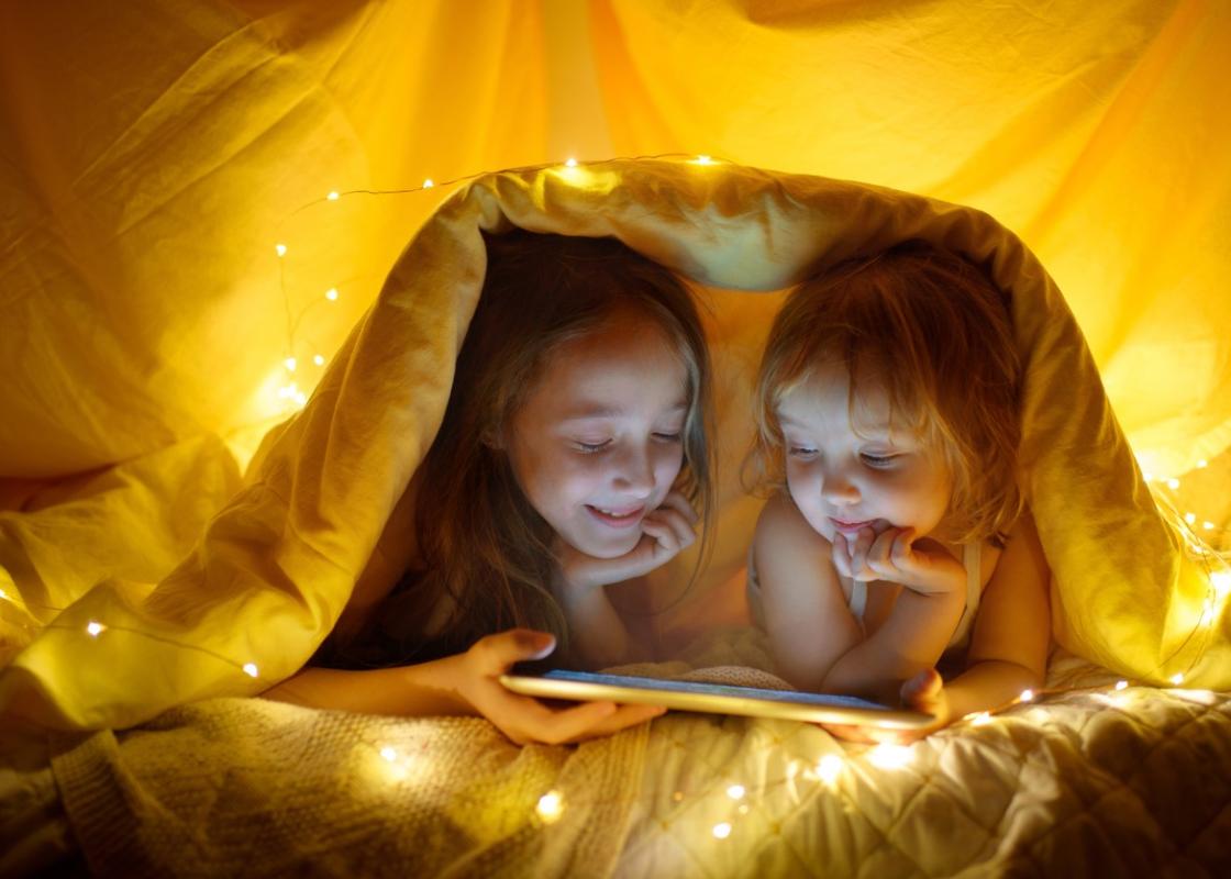 Two girls reading in a tent