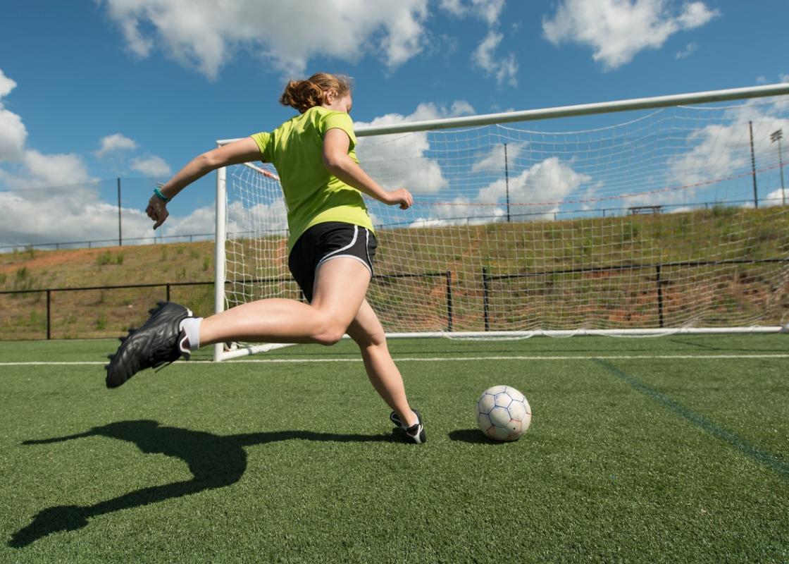 Jente i ferd med å skåre mål på fotballbanen