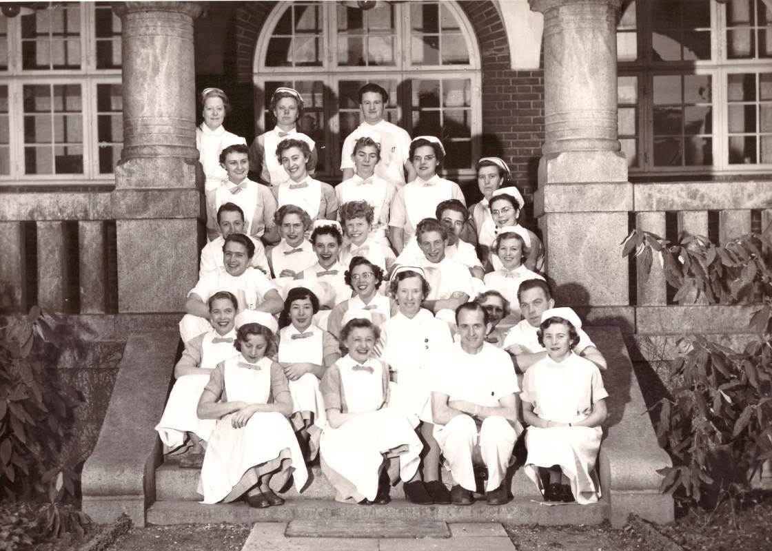 Bildet fra 1954 viser ferdige sykepleiere ved Rigshospitalet – med de første sju mannlige sykepleierne i Danmark. 