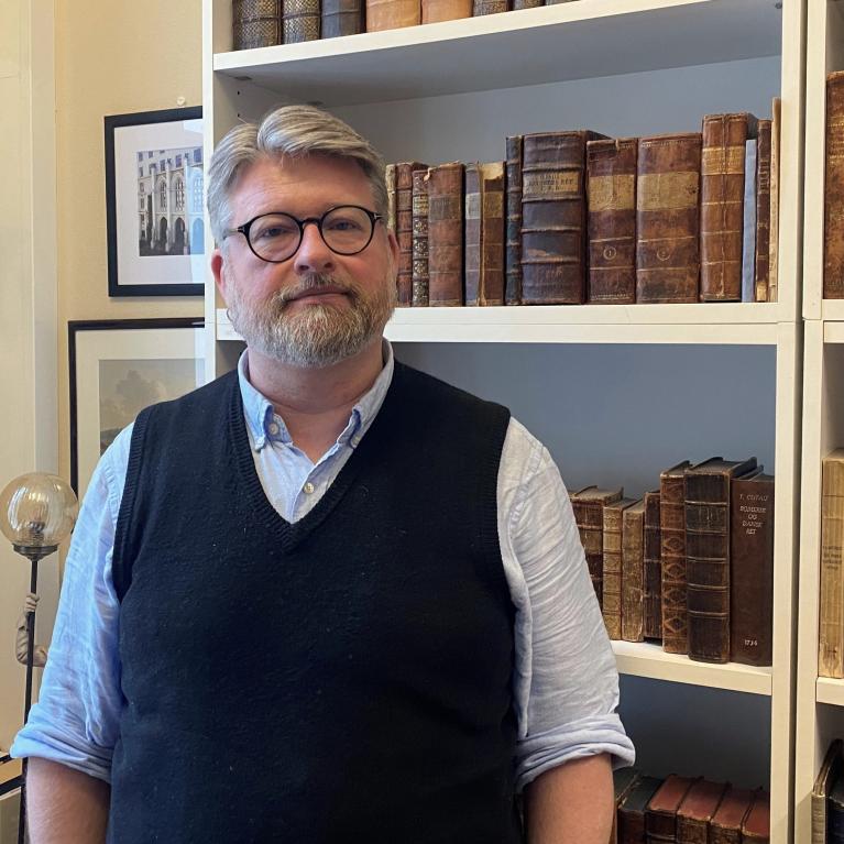 Jussprofessor Jørn Øyrehagen Sunde står foran bokhylla på kontoret sitt